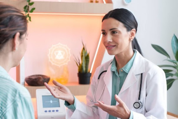 A compassionate female doctor in a white coat consulting a patient in a modern wellness clinic. The setting features warm lighting, holistic healing symbols, and bioenergetic testing equipment, emphasizing personalized and integrative healthcare.